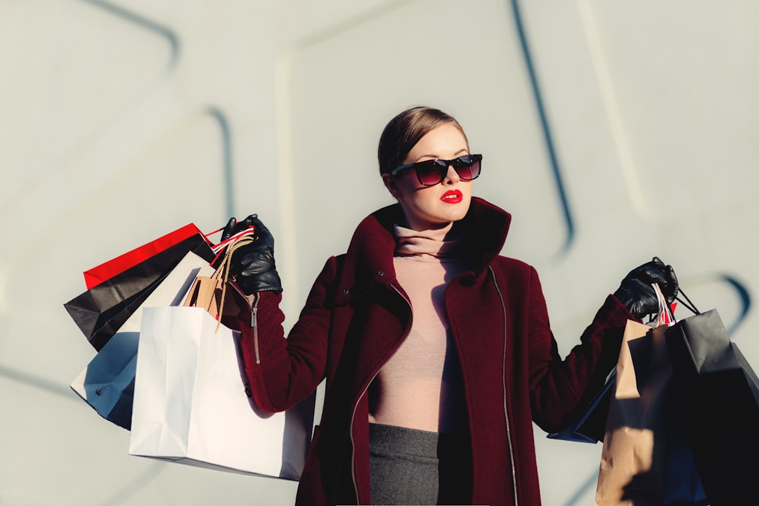 Shopping freak by Clothing Brands photo of woman holding white and black paper bags