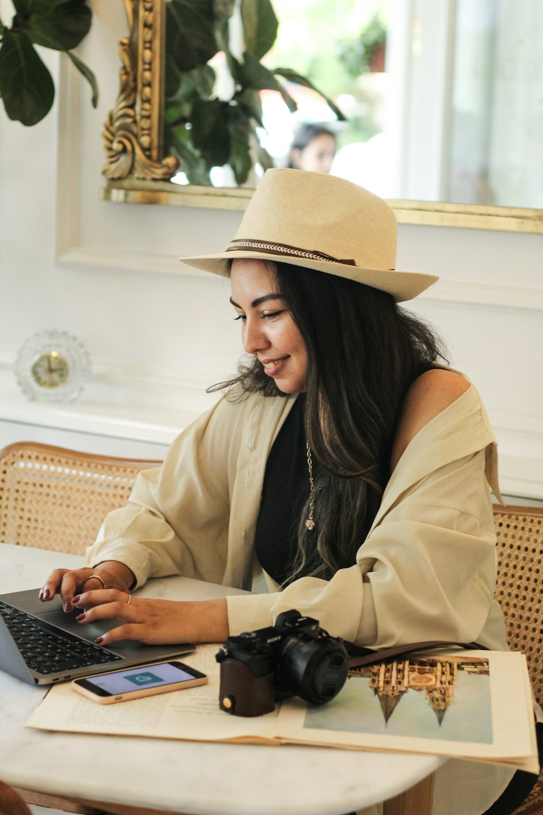 a woman sitting at a table using a laptop computer